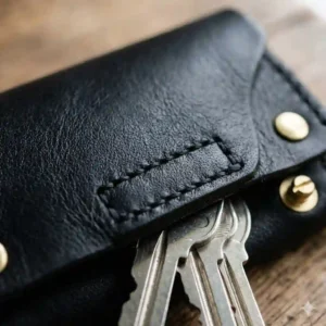 Close-up shot of the durable stitching and premium grain on a black leather key holder organizer.